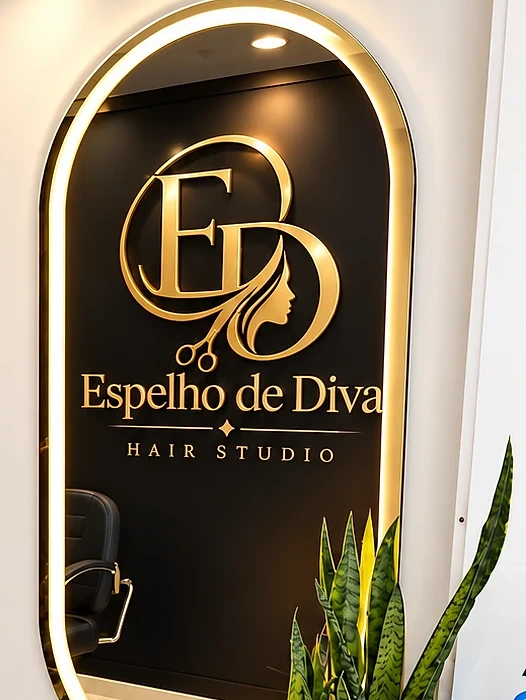 Espelho iluminado do salão com o logo dourado Espelho de Diva Hair Studio