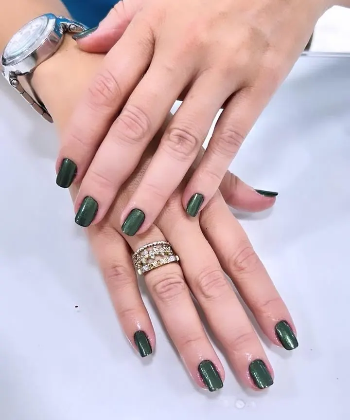 Unhas pintadas em verde escuro